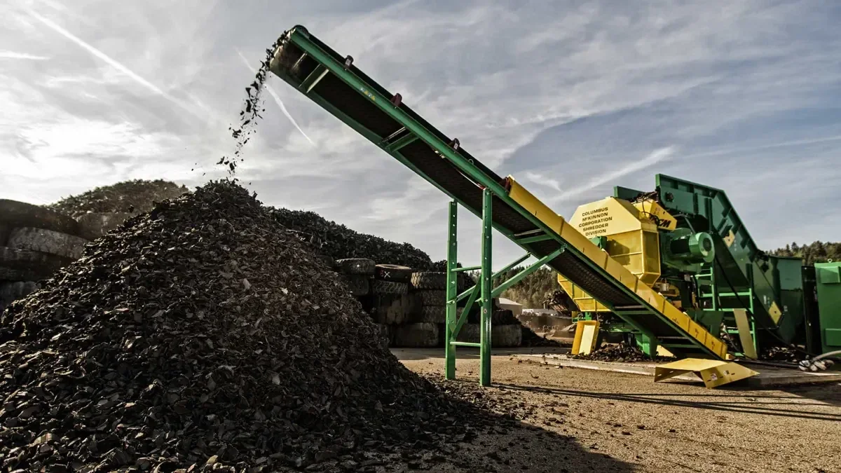 End-of-life tyres being shredded into chips at a tyre recycling yard
